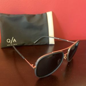 Quay black sunglasses with gold frame.